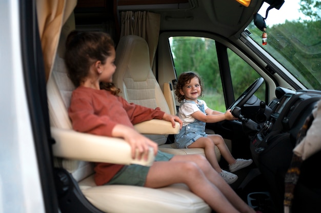 Niño de la familia nómada divirtiéndose en la furgoneta