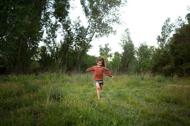 Foto gratuita niño de familia nómada divirtiéndose en la naturaleza