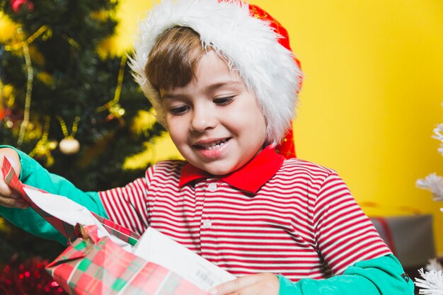 Foto gratuita niño feliz abriendo regalo