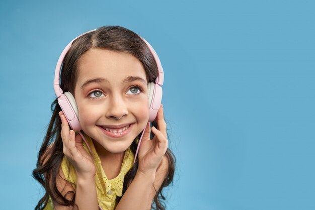 Niño feliz en auriculares escuchando música favorita en estudio