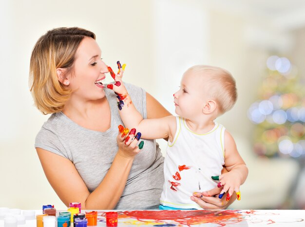 Niño feliz se basa en el rostro de su madre en casa.