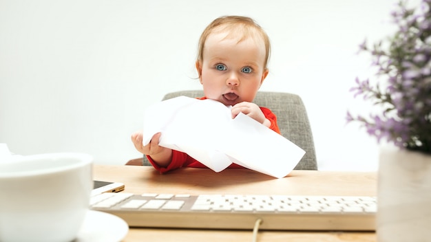 Niño feliz bebé niña niño pequeño sentado con el teclado de la computadora aislado sobre un fondo blanco.