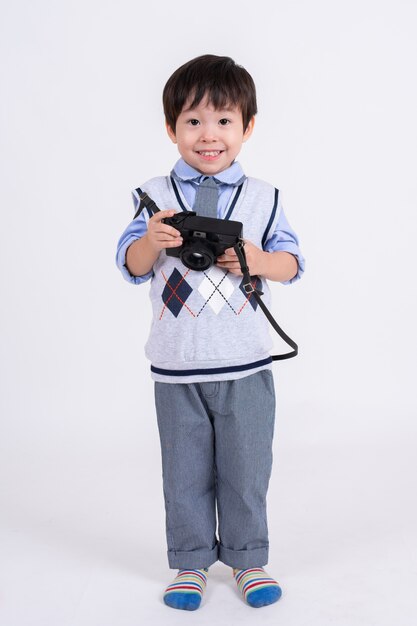 Niño feliz con la cámara en blanco