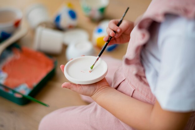 Niño feliz en casa hobby de pintura de olla de bricolaje