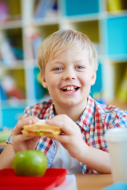 Niño feliz comiendo un bocadillo