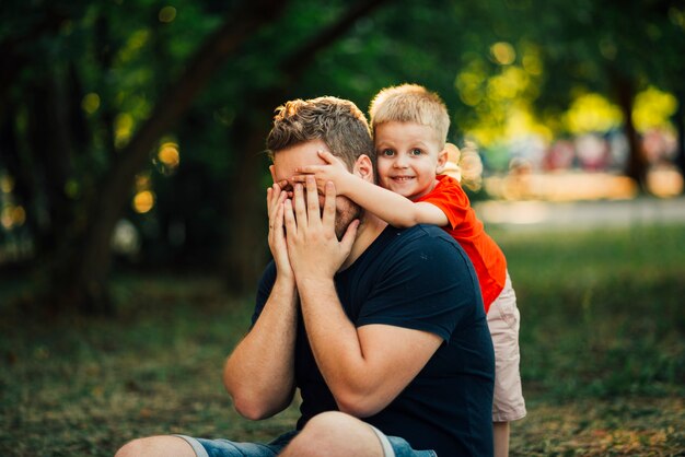 Niño feliz cubriendo los ojos de su padre