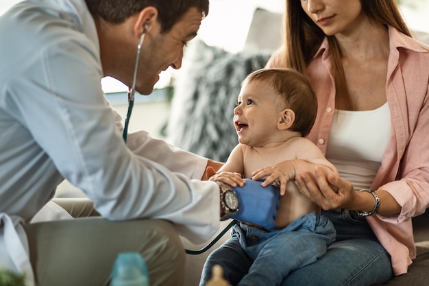 Niño feliz divirtiéndose mientras el médico escucha los latidos de su corazón con un estetoscopio