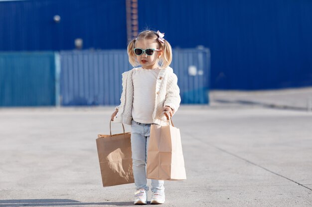 niño feliz está de compras al aire libre