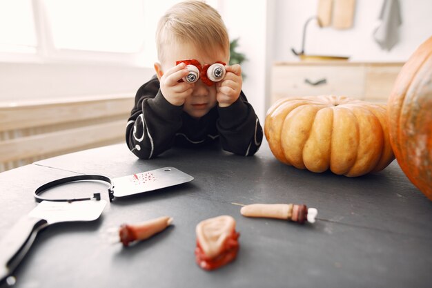 Niño feliz en la fiesta de Halloween. Diversión infantil en interiores. Bby vistiendo traje. Concepto de niños listos para una fiesta.