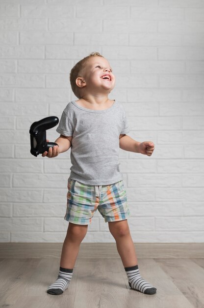Niño feliz jugando con joystick en casa