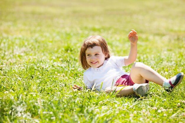 Niño feliz jugando en el prado de hierba