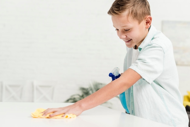 Niño feliz limpiando con un trapo