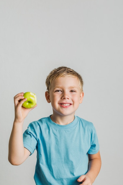 Niño feliz con una manzana verde