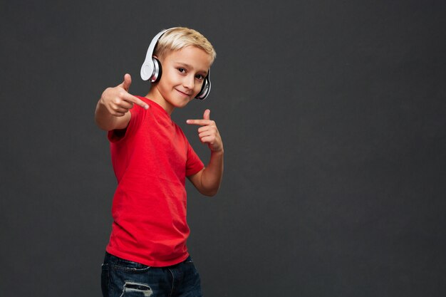Niño feliz niño escuchando música con auriculares.