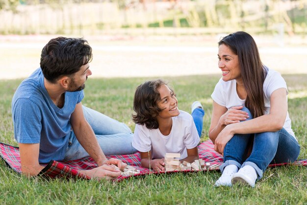 Niño feliz en el parque con padres disfrutando de su tiempo