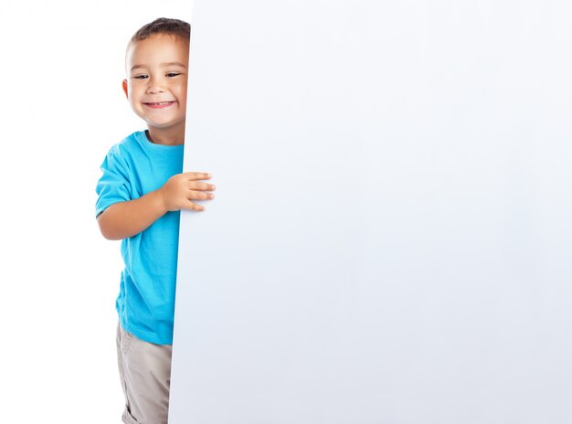 Niño feliz posando con un letrero vacío