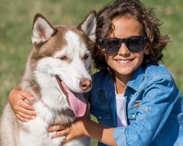 Niño feliz posando con perro en el parque