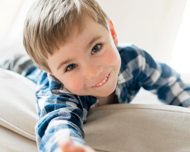 Niño feliz recostado en el sofá