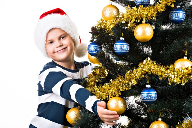 Niño feliz con regalo cerca del árbol de Navidad