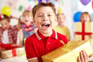 Foto gratuita niño feliz con regalo grande