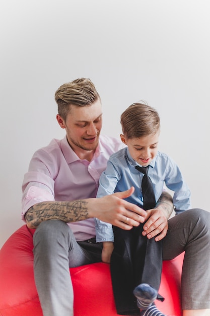 Niño feliz sentado en las piernas de su padre