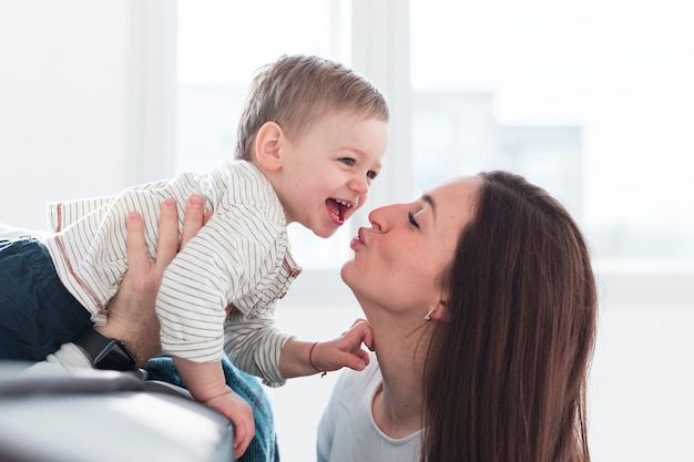 Niño feliz siendo besado por la madre