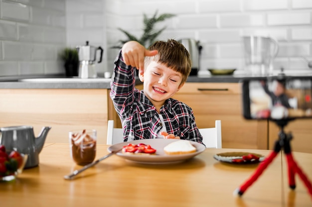 Niño feliz con teléfono y comida