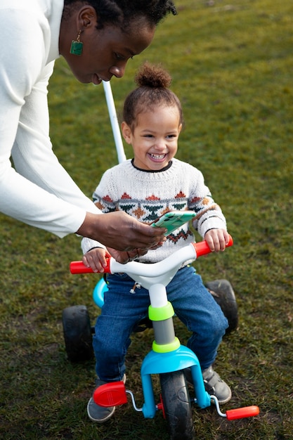 Niño feliz en triciclo alto ángulo