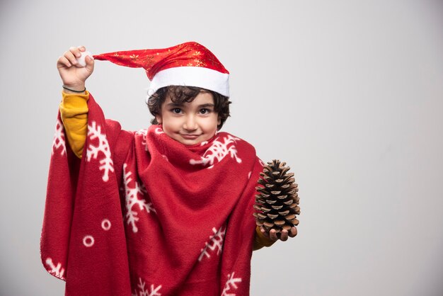 Niño feliz en uniforme rojo y sombrero con piña