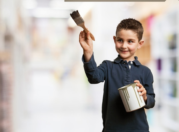 Foto gratuita niño feliz usando una brocha