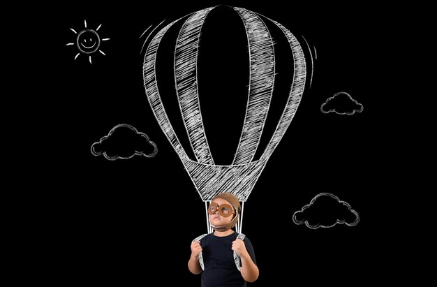 El niño finge ser un superhéroe y volará con un globo.