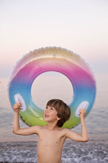 Niño con flotador junto al mar