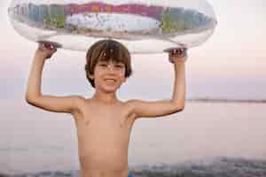 Foto gratuita niño con flotador junto al mar