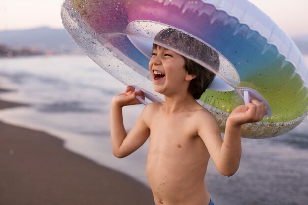 Niño con flotador junto al mar