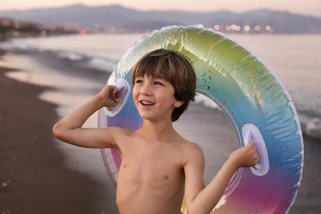 Foto gratuita niño con flotador junto al mar