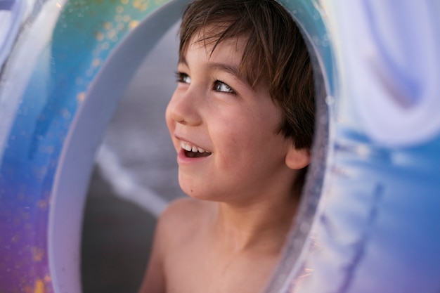 Niño con flotador junto al mar