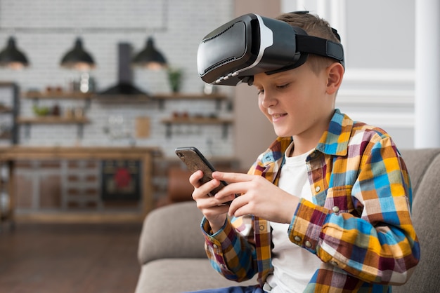 Niño con gafas de realidad virtual y smartphone