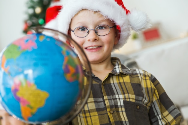 Foto gratuita niño con un globo del mundo