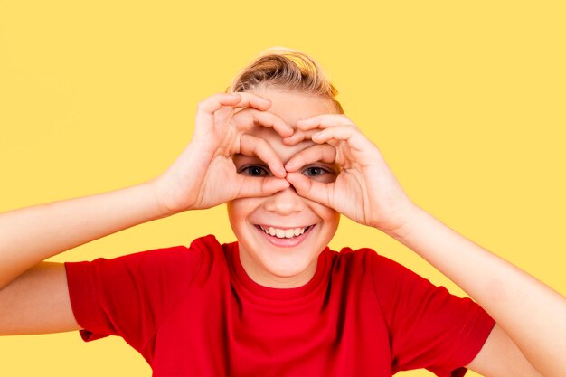 Niño haciendo binoculares con las manos en los ojos