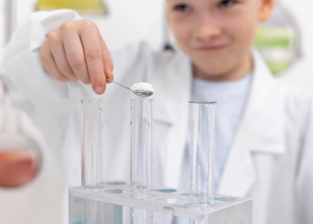 Niño haciendo un experimento científico en la escuela.