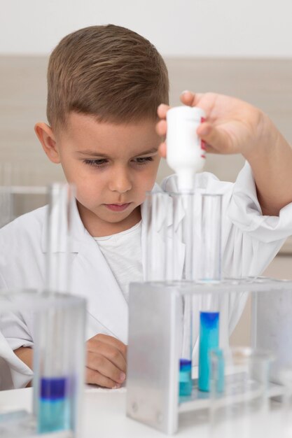 Niño haciendo un experimento científico en la escuela.