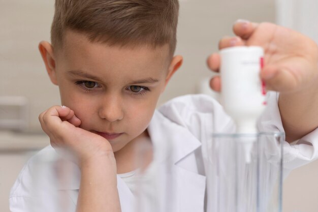 Niño haciendo un experimento científico en la escuela.