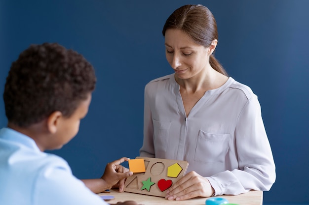 Foto gratuita niño haciendo una sesión de terapia ocupacional con un psicólogo.