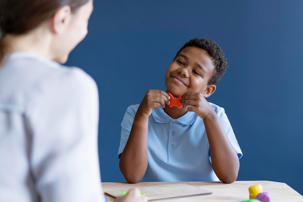 Niño haciendo una sesión de terapia ocupacional con un psicólogo.