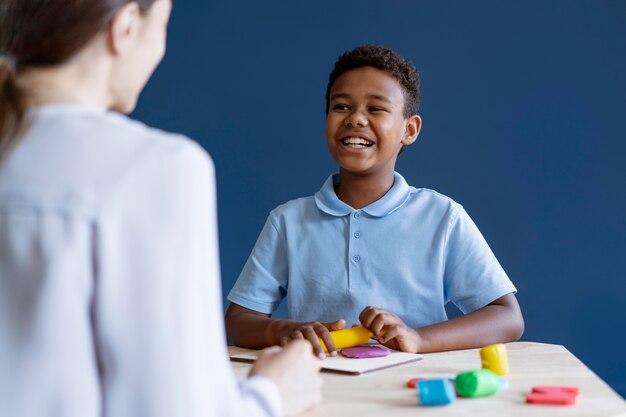 Niño haciendo una sesión de terapia ocupacional con un psicólogo.