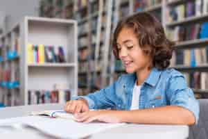 Foto gratuita niño haciendo sus deberes en la biblioteca