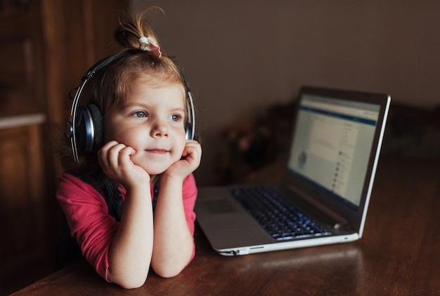 Niño hermoso feliz en auriculares escuchando música