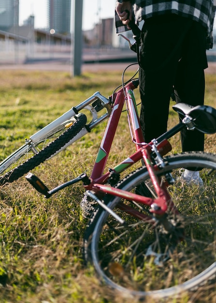 Niño en la hierba sosteniendo su bicicleta