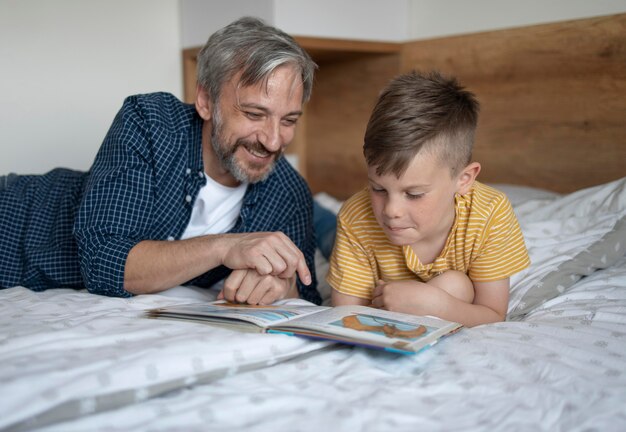 Niño y hombre de tiro medio leyendo