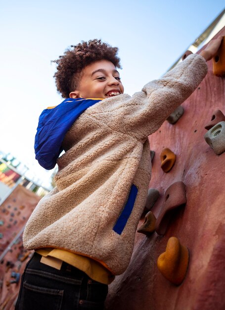 Niño intentando un muro de escalada